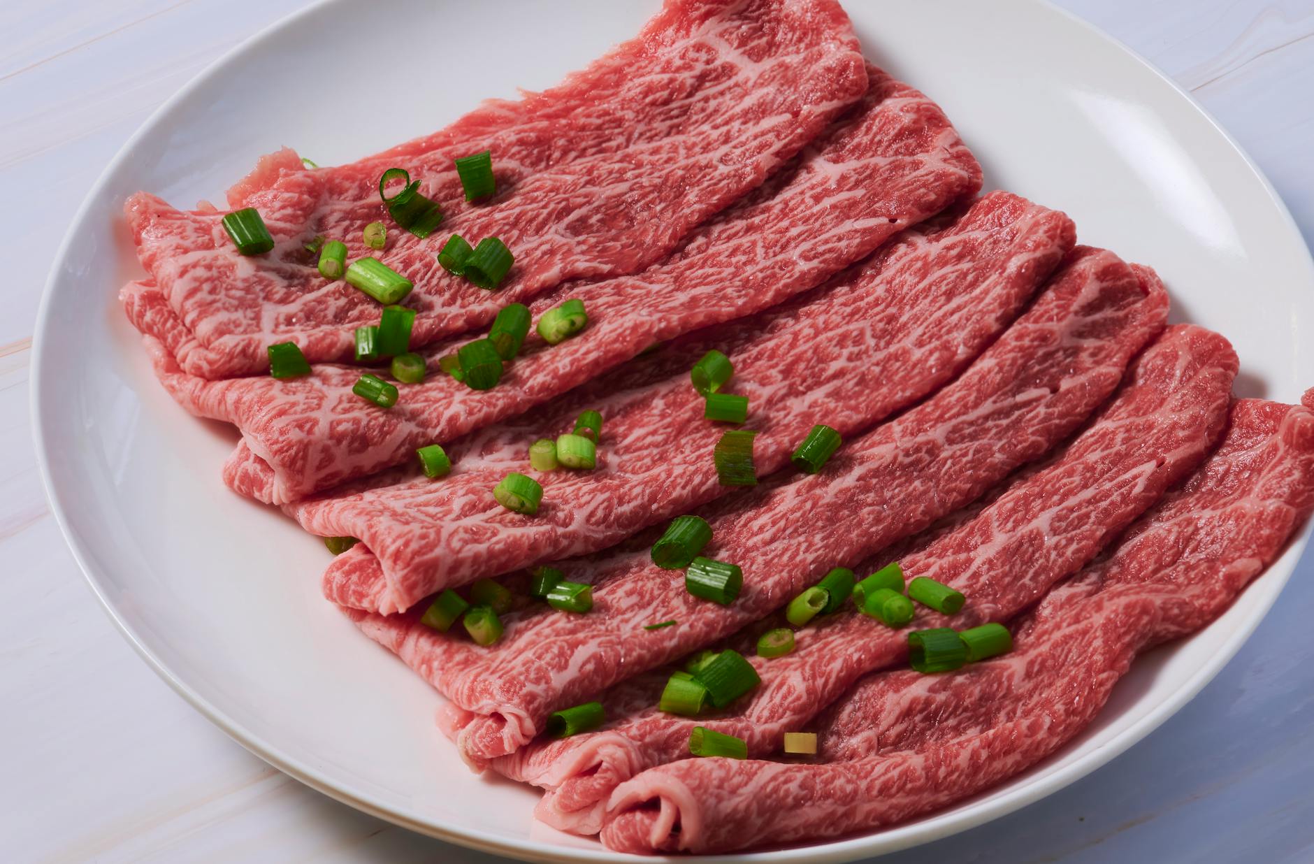 Marbled wagyu beef slices for sukiyaki on a plate