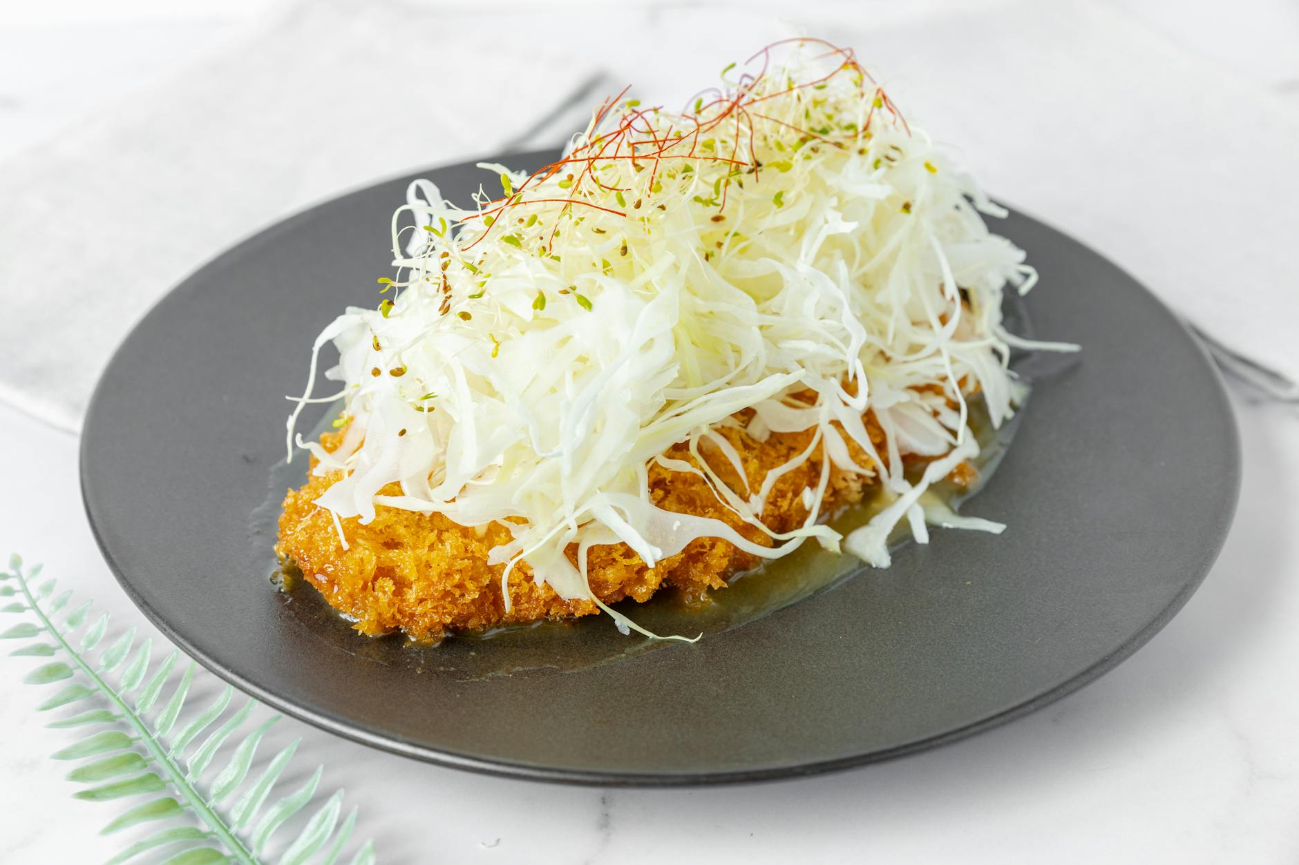A breaded pork cutlet (tonkatsu) topped with shredded cabbage